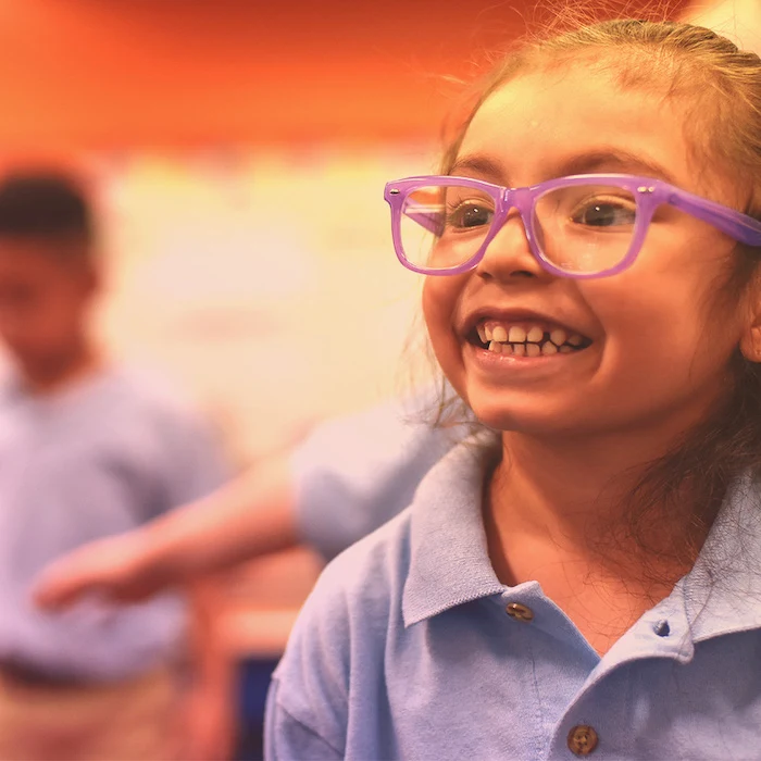 Girl in purple glasses smiles